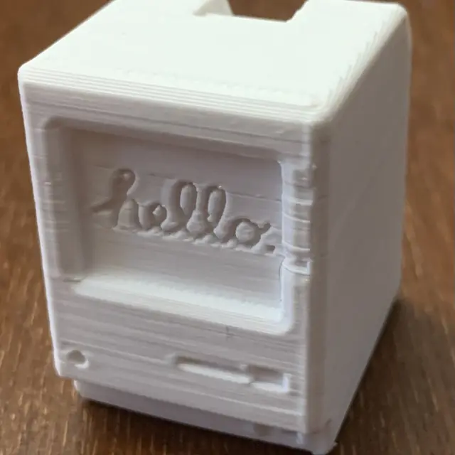 Mini počítač v štýle Macintosh s nápisom „hello“